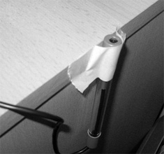 Obr. 4. Vlevo uchycení luxmetru ke hraně stolu pomocí papírové lepicí pásky.