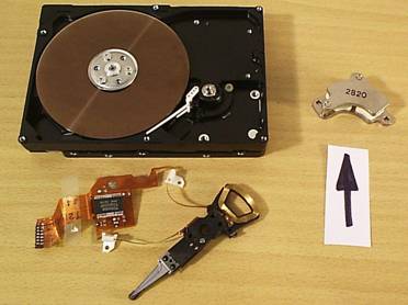 Zdenk Polk: Magnety - Obr. 9: Vnitek pevnho disku s demontovanm ramnkem a vyjmutm magnetickm obvodem s magnety (oznaen ipkou).