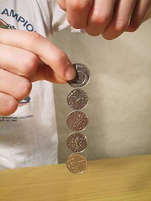 Zdenk Polk: Magnety - Obr. 7: Mince zmagnetovan magnetem v horn ruce. Pi vzdalovn magnetu postupn odpadvaj.