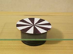 Zdenk Polk: Magnety - Obr.8: Hlinkov koleko rotujc na skle, s osou totonou s osou symetrie magnetickho pole.